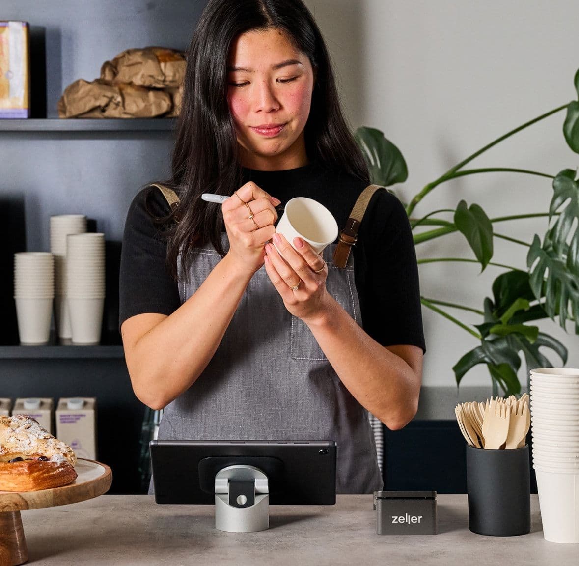 Merchant writing on coffee cup in cafe