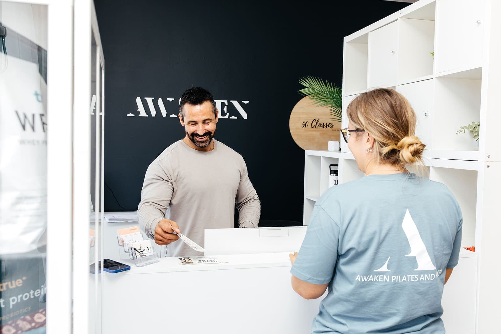 Helping customer at Awaken Pilates and Yoga